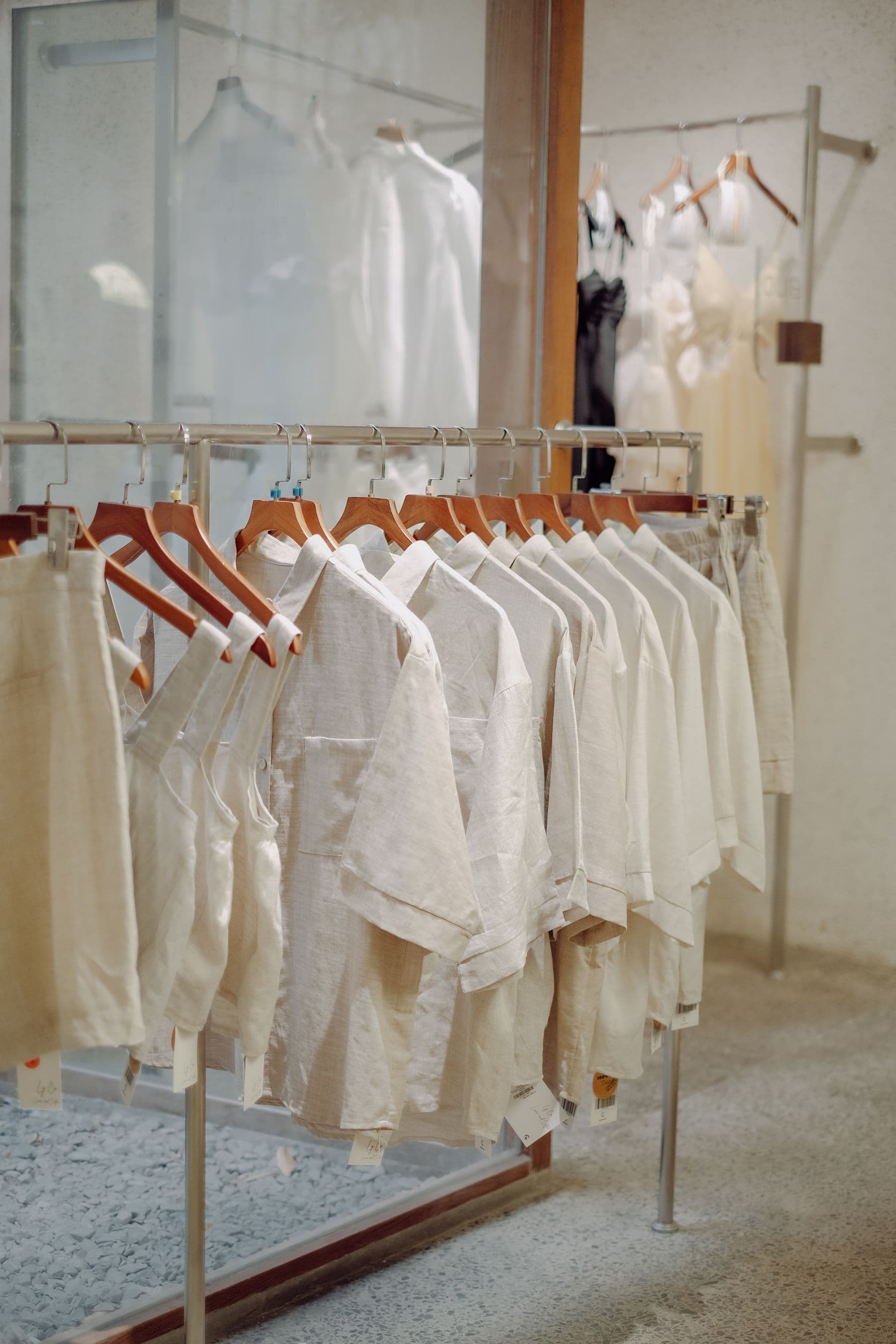 Camisas de lino en tonos crudos colgadas en una barra